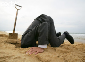 Businessman With Head in Sand --- Image by © cocorophotos/Bloomimage/Corbis